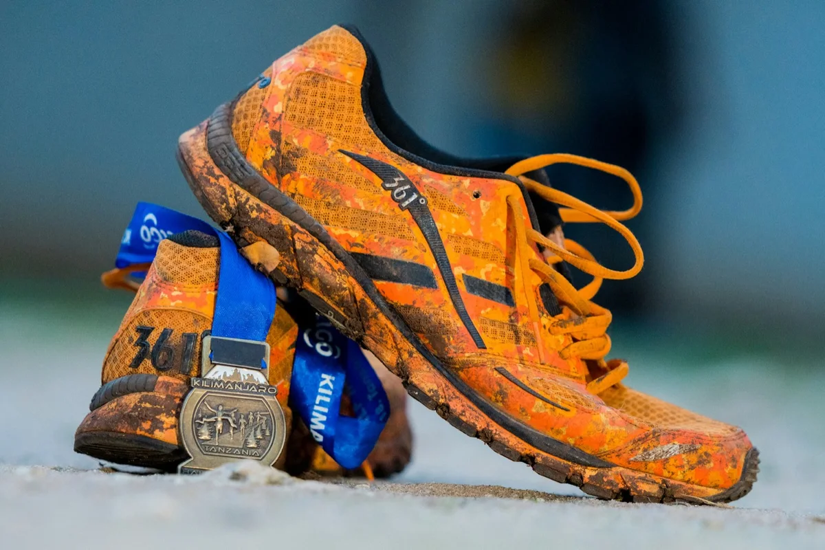 Running shoes, a race bib and a finisher medal after a race