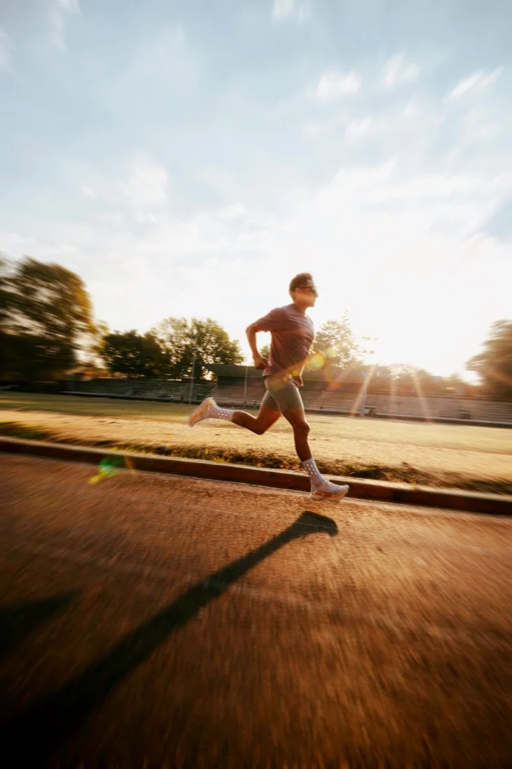 A runner moving through a track session in the late afternoon